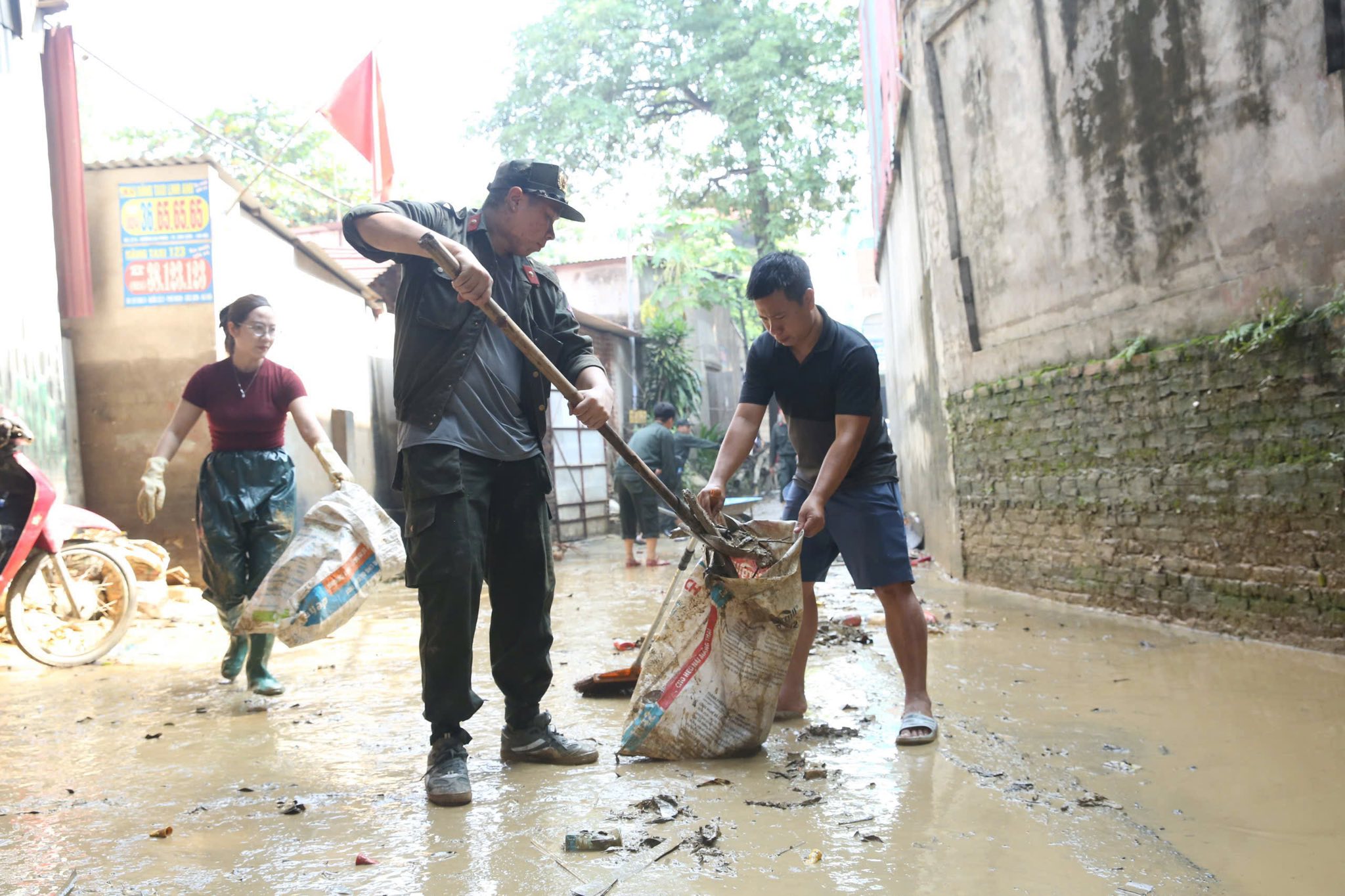 Chùm ảnh: Công an Hà Nội giúp dân dọn dẹp bùn đất sau khi nước rút
