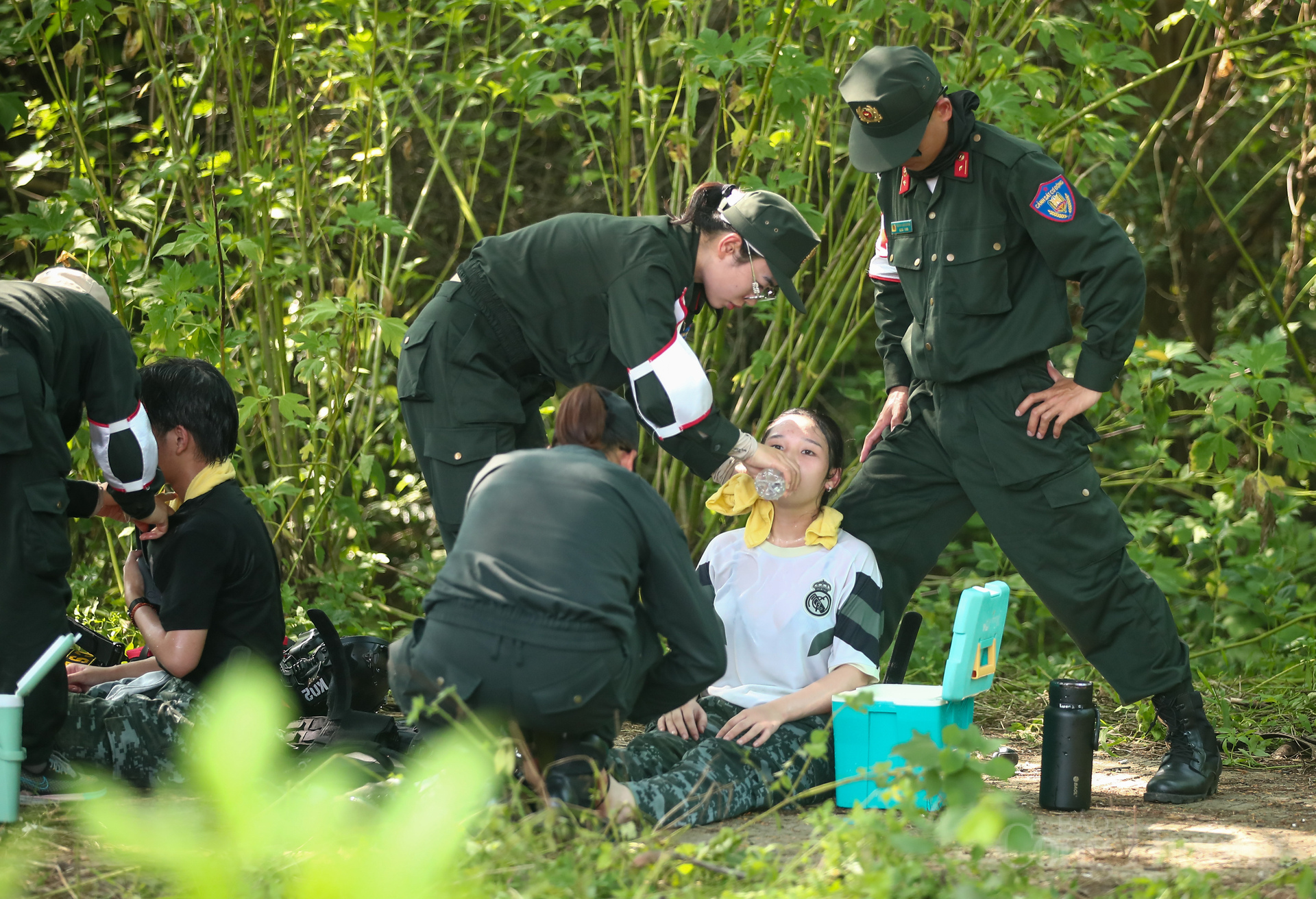 Họ nhanh chóng sử dụng xô nước đá mang theo bên mình, nhúng khăn mát lau mặt và khắp cơ thể chiến sĩ để hạ nhiệt. Có người dùng bình xịt, khăn lạnh hoặc nước mát tưới trực tiếp lên tay, cổ, trán các chiến sĩ... Các hoạt động đều được thực hiện nhịp nhàng, dứt khoát, đúng quy trình sơ cấp cứu. Nhờ sự can thiệp kịp thời và chuyên nghiệp, chiến sĩ đã nhanh chóng hồi tỉnh, tiếp tục được theo dõi để đảm bảo an toàn.