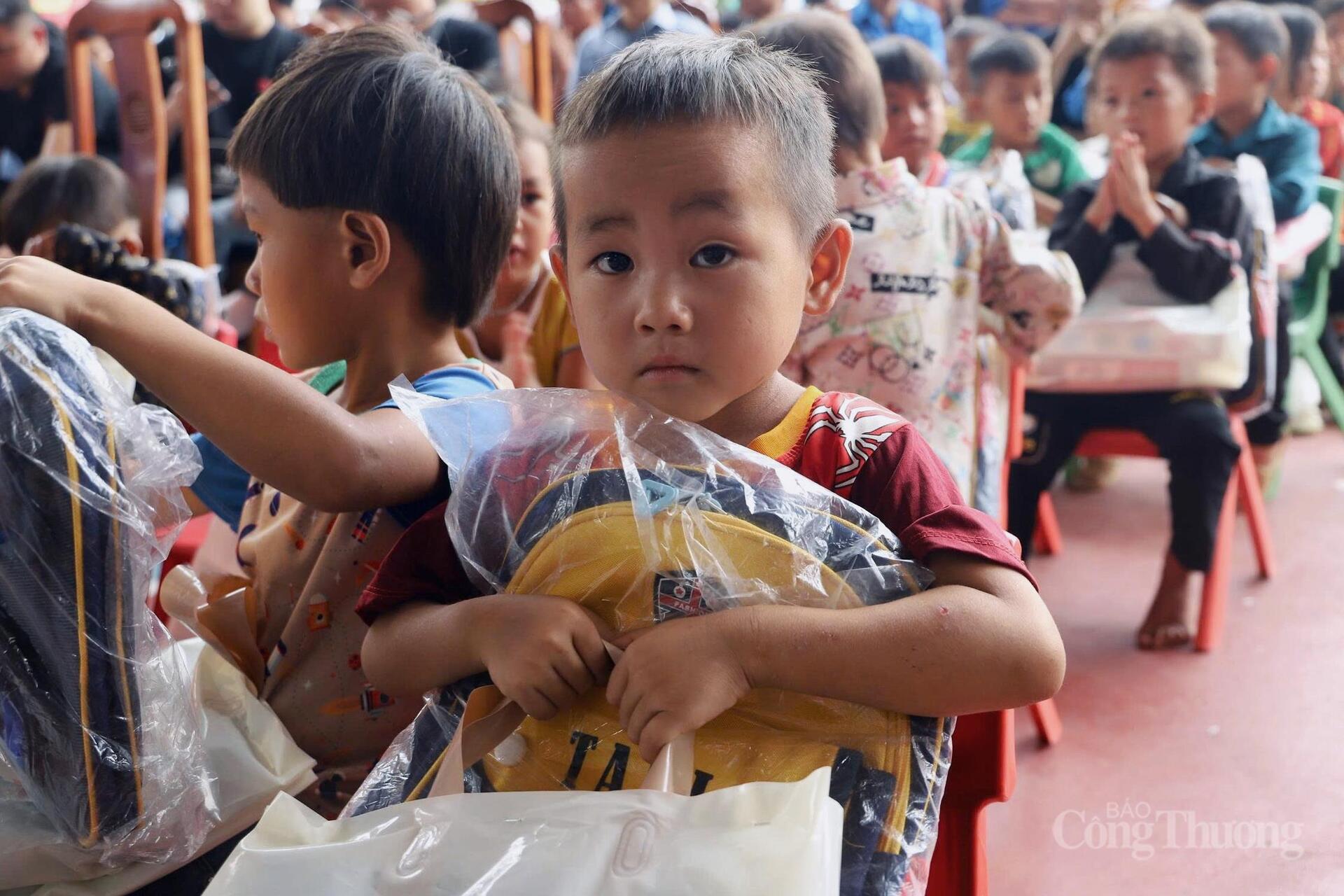 Các em bẽn lẽn đón nhận, đôi bàn tay nhỏ khẽ ôm chặt gói quà như sợ rơi mất, ánh mắt ngại ngùng lúng túng chẳng biết nói lời cảm ơn bằng tiếng Kinh.