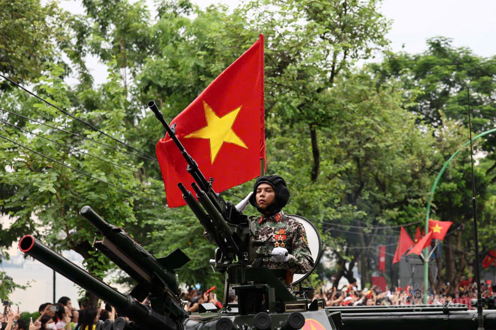 Các chiến sĩ giơ tay chào cờ dưới Quốc kỳ