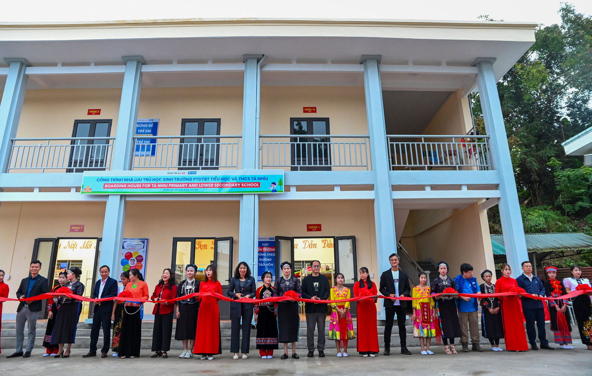 Ông Yukihiro Nitta, Tổng Giám đốc phụ trách Phát triển Bền vững Tập đoàn Fast Retailing, bà Lê Quỳnh Lan, Giám đốc Quốc gia Plan International Việt Nam cùng các đại diện địa phương cắt băng khánh thành nhà bán trú Trường Phổ thông Dân tộc Bán trú Tiểu học và Trung học Cơ sở Tả Nhìu.