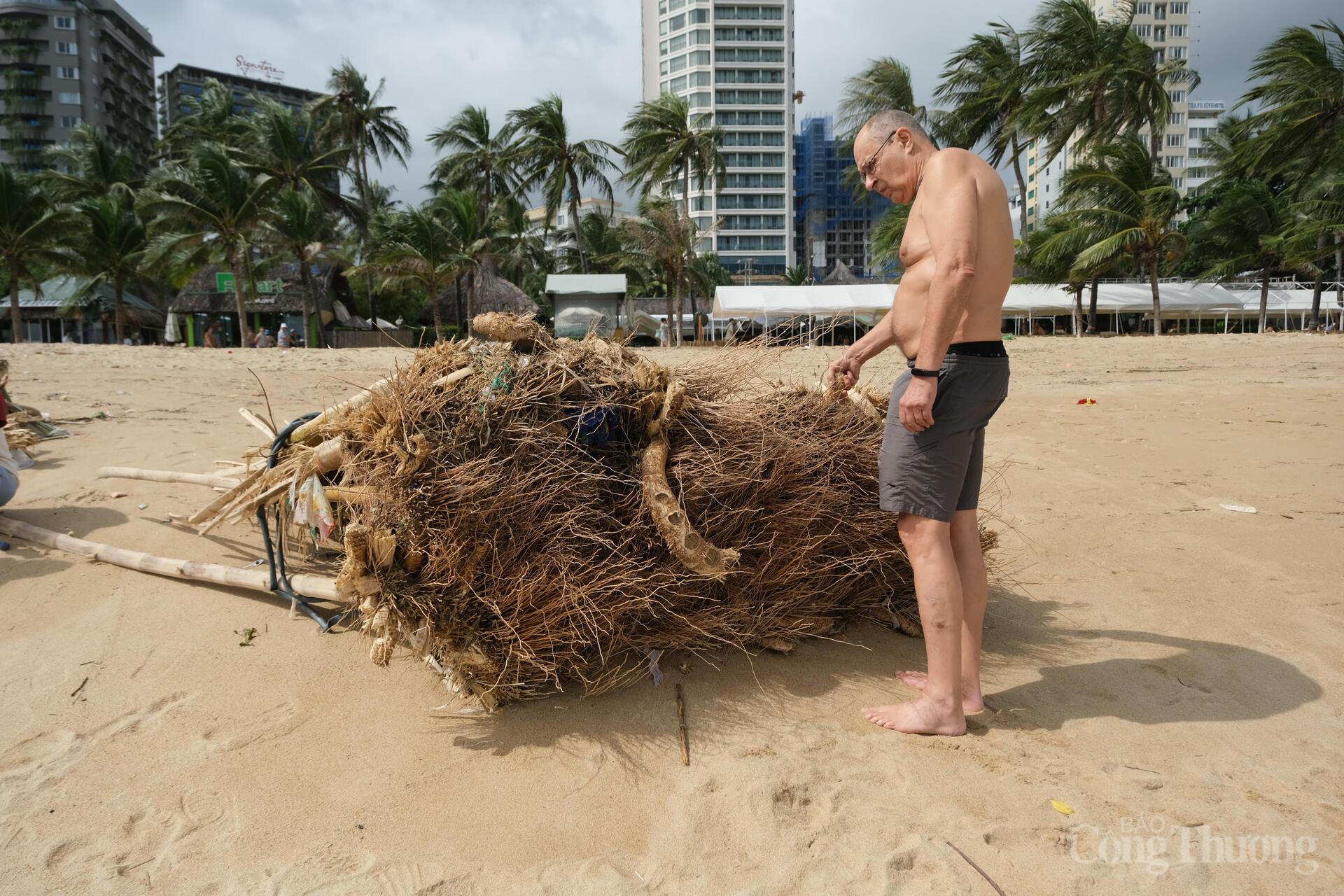 Du khách người nước ngoài tò mò về gốc tre bị sóng đánh dạt vào bờ biển. Ảnh: Lê Sơn