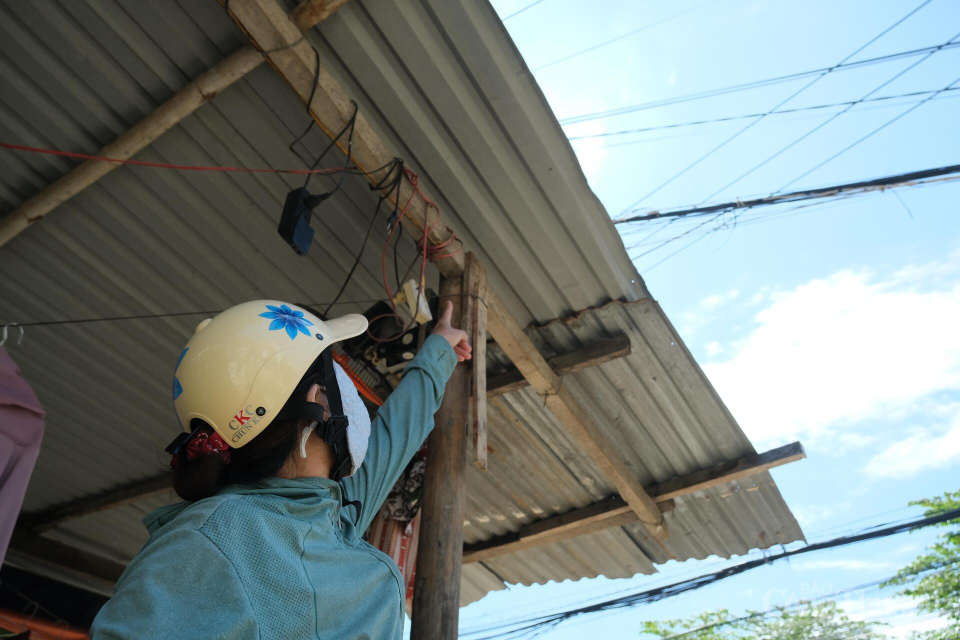 Chị Võ Thị Phương Thảo, tổ 1, chợ Vĩnh Điềm Trung, phường Tây Nha Trang chỉ nơi nước lũ dâng tới vị trí ổ cắm điện. Ảnh: Lê Sơn