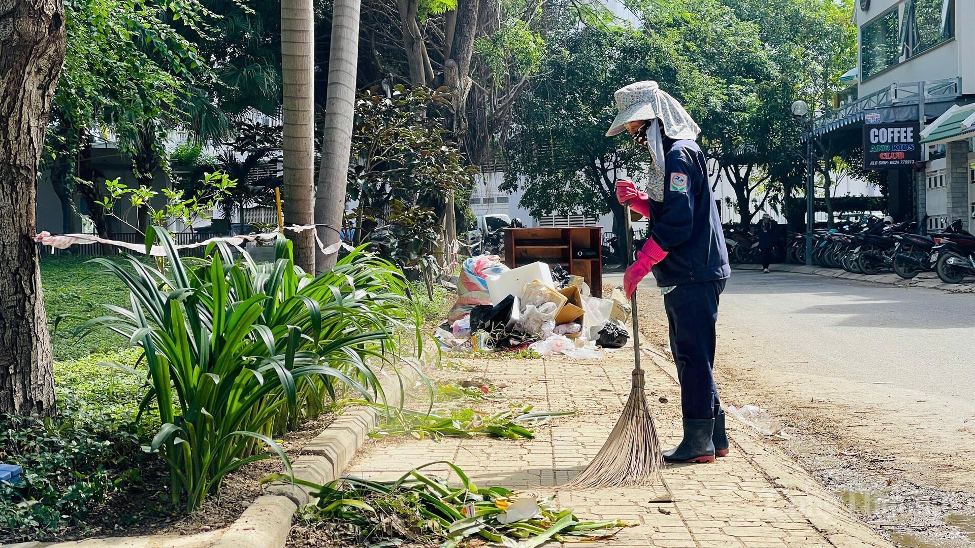 Cô L. T. N. Công ty Môi trường đô thị Khánh Hòa, đang dọn dẹp tại đường C1, trung tâm công viên bờ hồ, phường Tây Nha Trang. Ảnh: Lê Sơn