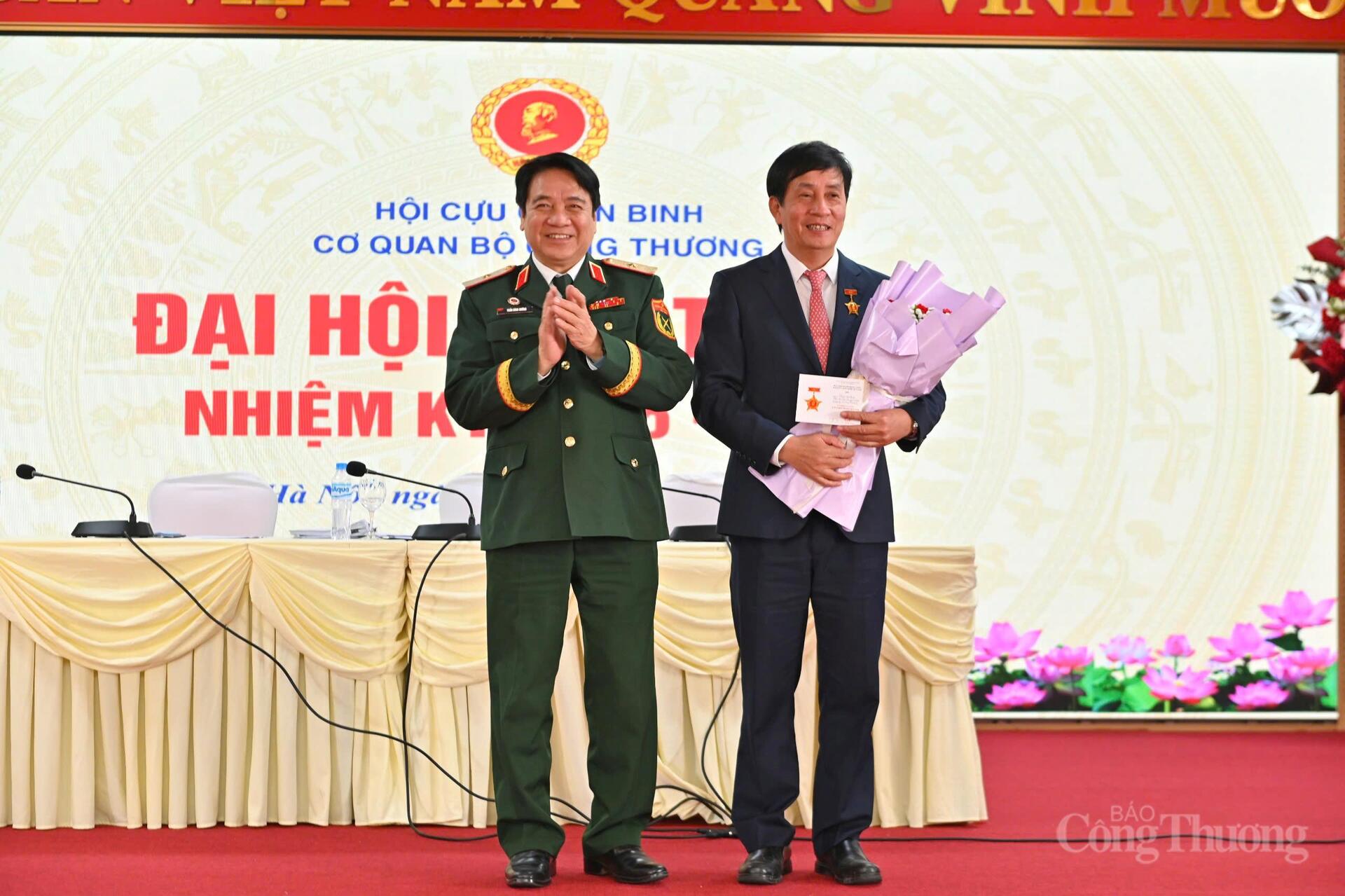 Đồng chí Trần Đình Hướng, Ủy viên Ban Thường vụ, Phó Trưởng ban công tác Hội Cựu chiến binh Việt Nam trao hoa, và kỷ niệm chương cho đồng chí Phan Văn Bản - Phó Bí thư Đảng ủy Bộ Công Thương