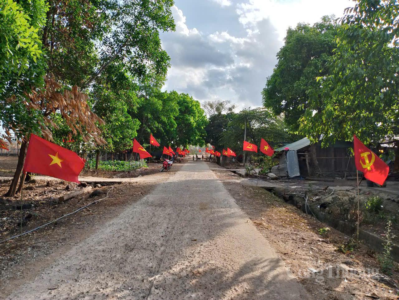 Cờ Đảng, cờ Tổ quốc tung bay phấp phới dọc tuyến đường dẫn vào Buôn H'Mông, xã Ea Kiết