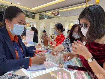 Người dân đeo khẩu trang, xếp hàng chờ tới lượt mua vàng ngày Thần tài