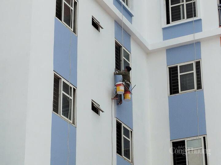 Công nhân tích cực sơn lại bên ngoài tòa nhà.