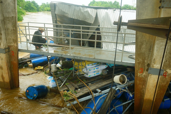 Lồng bè vướng vào cửa van cản trở dòng chảy của nước. Ảnh: Vũ Lê