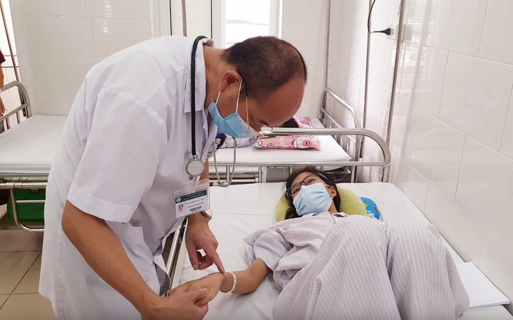 PGS.TS Đỗ Duy Cường thăm khám cho bệnh nhân sốt xuất huyết - Ảnh: Mai Thanh