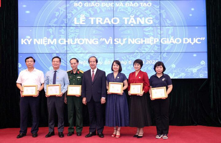 Bộ trưởng Bộ Giáo dục và Đào tạo Nguyễn Kim Sơn trao tặng Kỷ niệm chương “Vì sự nghiệp giáo dục” cho các nhà báo. Ảnh: Trần Hiệp