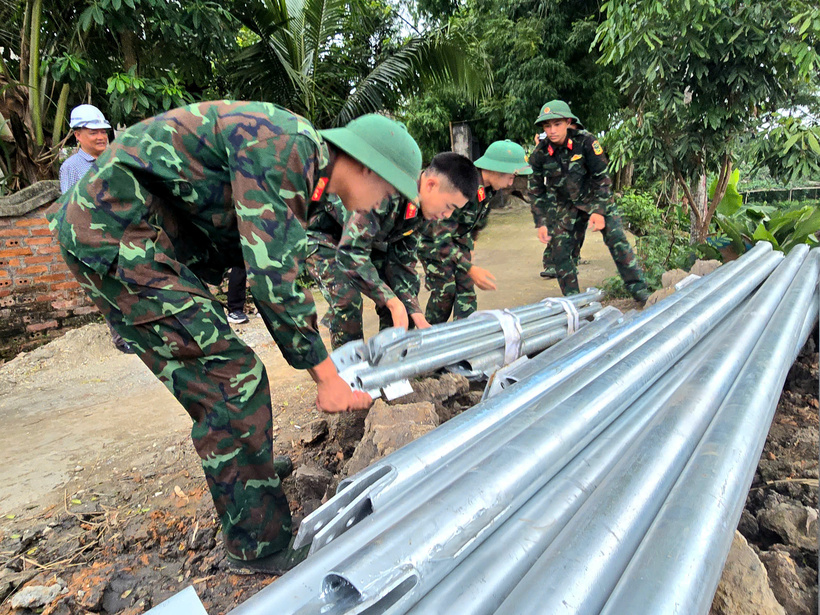 Lực lượng quân đội hỗ trợ vận chuyển thiết bị đến vị trí thi công. Ảnh: Thu Hường