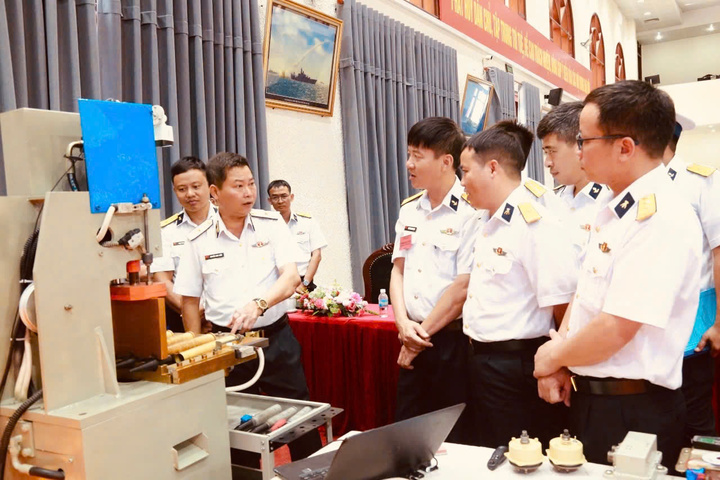 Chuẩn đô đốc Nguyễn Anh Tuấn cùng các đại biểu tham quan mô hình thiết bị tháo gỡ đạn pháo lắp chặn của Phòng hậu cần - kỹ thuật vùng. Ảnh: Minh Châu