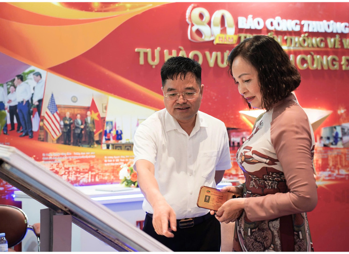 Tổng Biên tập Báo Công Thương Nguyễn Văn Minh giới thiệu các ấn phẩm của Báo cho quan khách tham quan gian trưng bày.