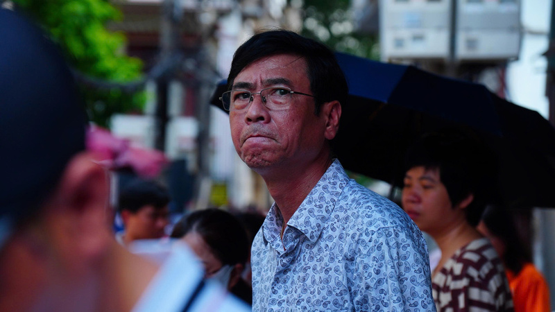 Một phụ huynh lo lắng cho con khi chỉ còn 5 phút làm bài môn Ngữ Văn. (Ảnh: Phương Ly)