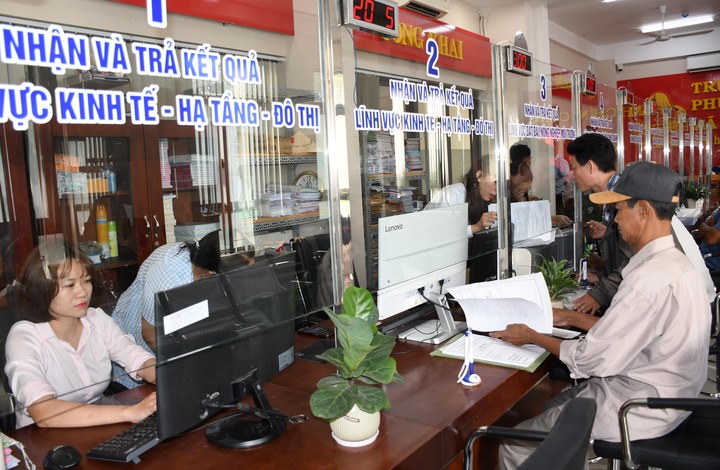 Cán bộ, công chức tận tình hỗ trợ người dân thực hiện thủ tục hành chính nhanh chóng, hiệu quả trong ngày đầu chính thức vận hành chính quyền hai cấp ở TP. Hồ Chí Minh. Ảnh: Minh Khuê.