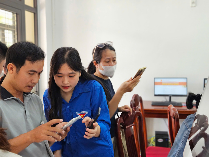 Bên cạnh các cán bộ công chức, phường Hòa Khánh còn huy động các đoàn viên, thanh niên hướng dẫn người dân thực hiện các thao tác thủ tục hành chính trên thiết bị điện tử. (Ảnh: Vũ Lê)