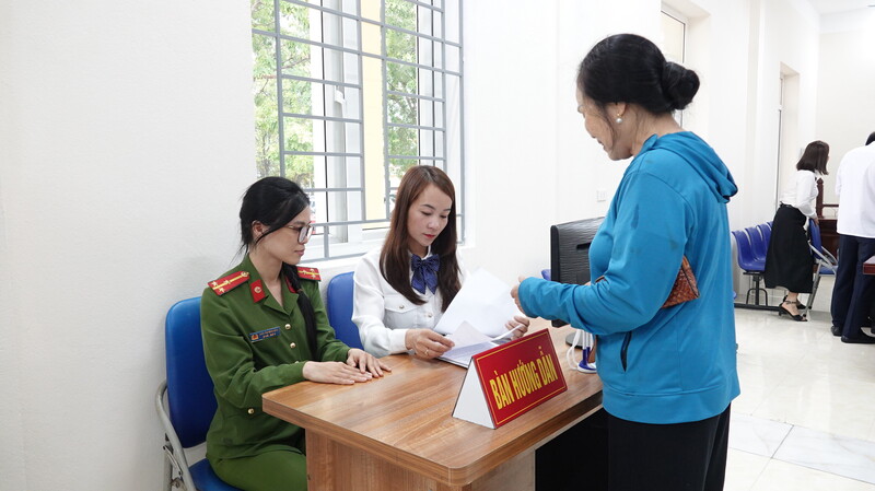 Một công dân được cán bộ Trung tâm phục vụ hành chính công hướng dẫn giải quyết thủ tục hành chính