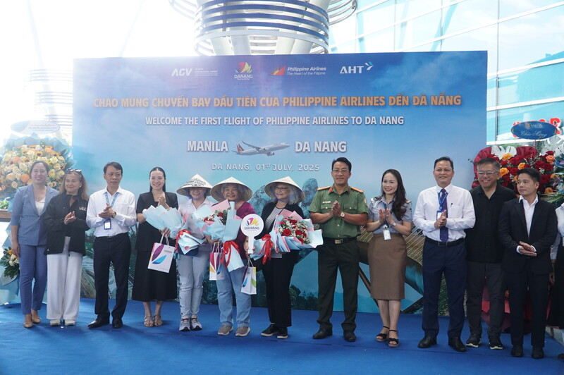 Tặng hoa, quà lưu niệm cho 3 hành khách đầu tiên trên chuyến bay trực tiếp Manila – Đà Nẵng trưa 1/7. Ảnh: Vũ Lê