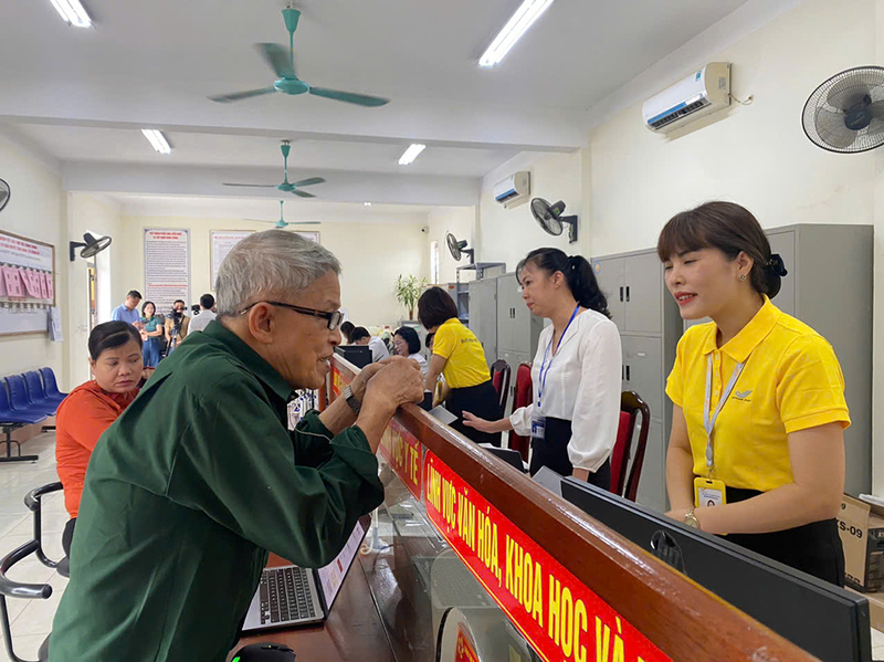 Nhân viên Bưu điện tỉnh Thái Nguyên hỗ trợ người dân tại Trung tâm Phục vụ hành chính công xã Đồng Hỷ, tỉnh Thái Nguyên. Ảnh: Thu Giang