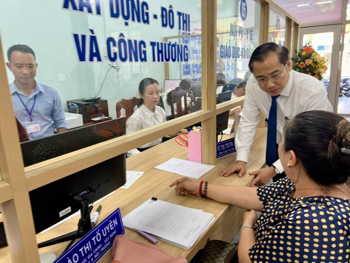 Lãnh đạo phường Tam Thắng hỏi thăm người dân trong quá trình làm thủ tục hành chính. Ảnh: Nguyễn Ngọc