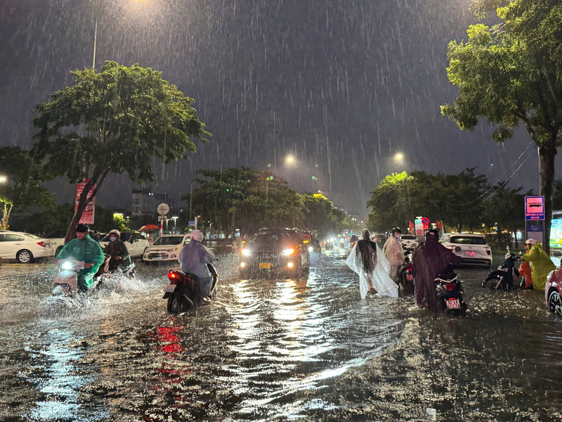 Mưa lớn xối xả tại đường Hàm Nghi, hàng trăm xe máy bị vào nước phải dắt bộ (Ảnh: Vũ Lê)