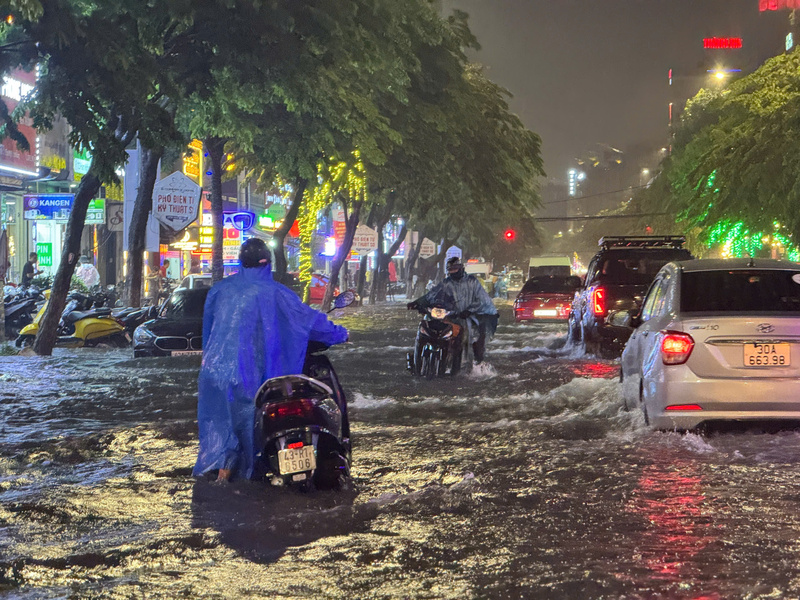 Bì bõm dắt bộ xe giữa "biển nước" (Ảnh: Vũ Lê)