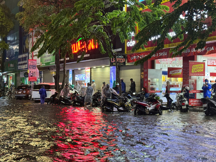 Nhiều xe máy bị chết máy phải dắt lên lề đợi nước rút (Ảnh: Vũ Lê)