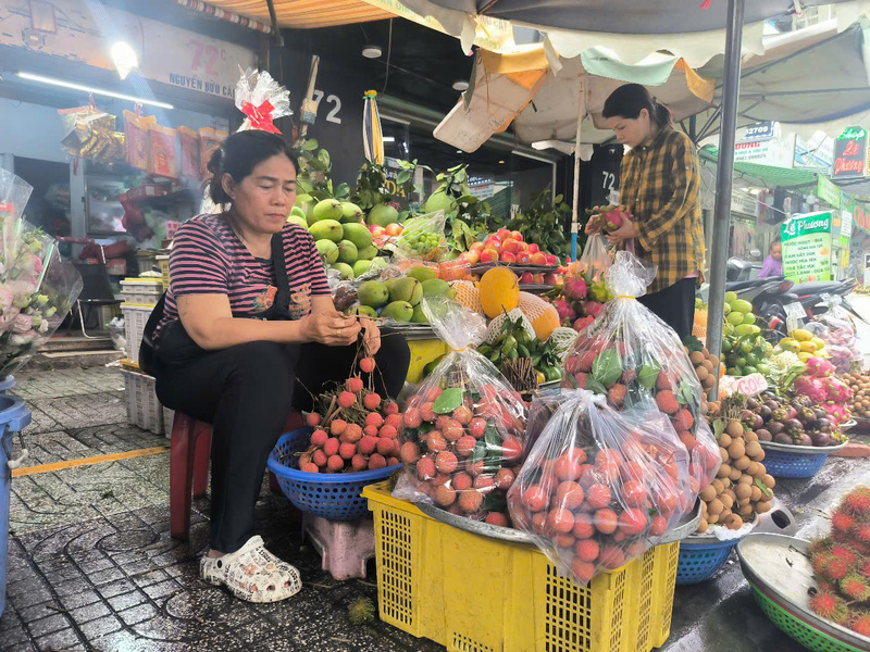 Tiểu thương bán vải thiều tại chợ Tân Định. Ảnh: Nguyễn Ngọc