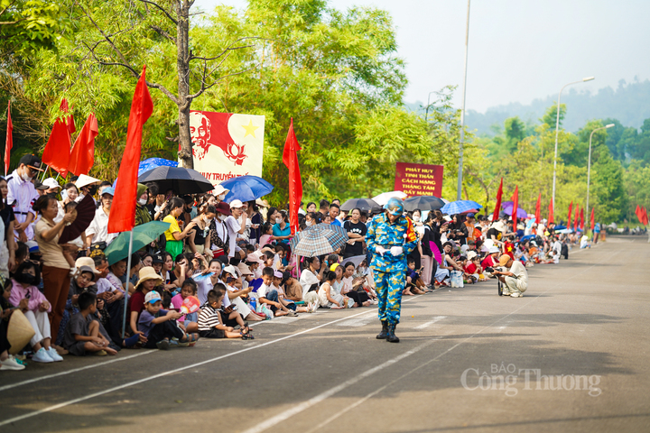 Người dân đội nắng để ngồi chờ hai lần tập luyện của cán bộ chiến sĩ trong buổi sáng ngày 9/7