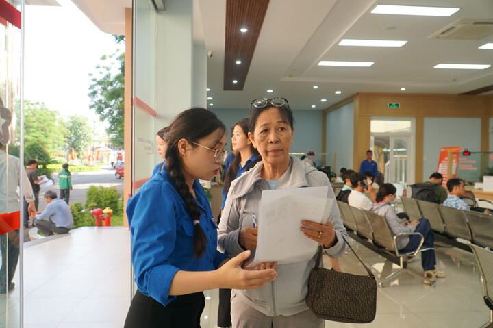 Khi người dân đến thực hiện thủ tục hành chính sẽ có các bạn đoàn viên, thanh niên của phường đón từ ngoài cửa vào và hướng dẫn đến vị trí thực hiện thủ tục hành chính theo từng lĩnh vực. Ảnh: Vũ Lê