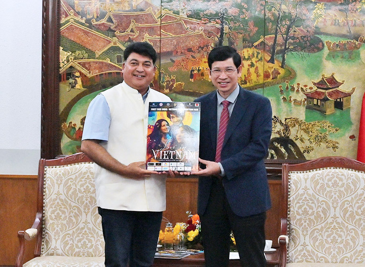 Ông Hồ An Phong (phải) và đạo diễn Rahul Bali (trái) chụp hình lưu niệm bên poster phim Love in Vietnam. (Ảnh: TITC)