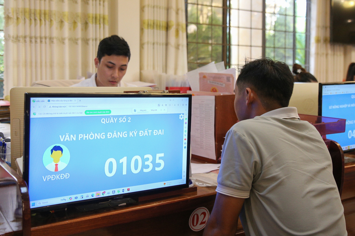 Cán bộ Trung tâm hướng dẫn người dân làm thủ tục đất đai. Ảnh: Quảng Phú