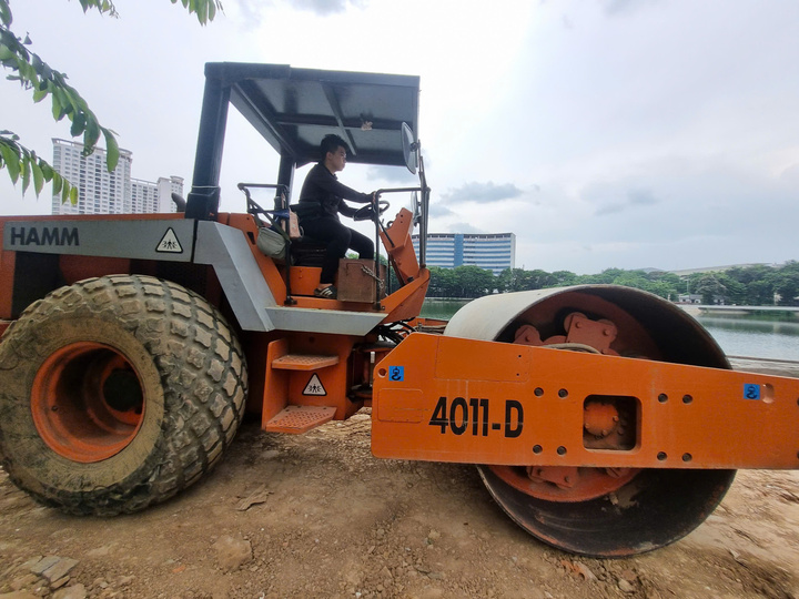 Anh Trần Ngọc Quân, công nhân điều khiển xe lu nén đất, thi công nền đường dạo ven hồ.
