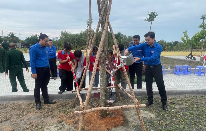 Các đại biểu cùng đoàn viên thanh niên trồng cây xanh trong khuôn viên khu di tích. Ảnh: T.A