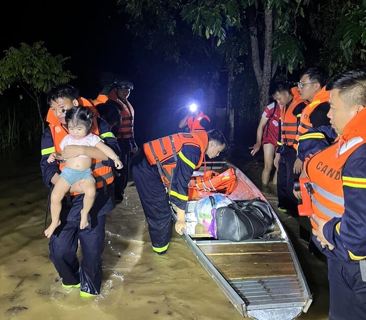 Cán bộ, chiến sĩ Công an tỉnh Nghệ An xuyên đêm hỗ trợ di chuyển người và tài sản đến nơi an toàn. Ảnh: Công an Nghệ An