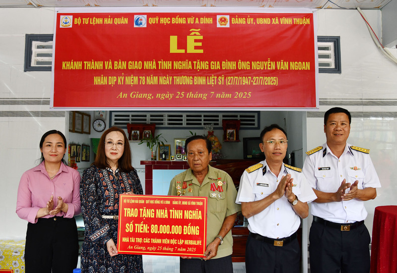 Đại diện nhà tài trợ và thủ trưởng Bộ Tư lệnh Vùng 5 Hải quân trao biển tượng trưng số tiền hỗ trợ xây dựng nhà tình nghĩa tặng gia đình ông Ngoan