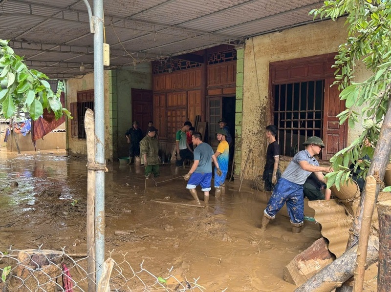Nhiều nơi bùn ngập sâu, lực lượng chức năng đang tích cực hỗ trợ người dân dọn dẹp. Ảnh: Công an Nghệ An