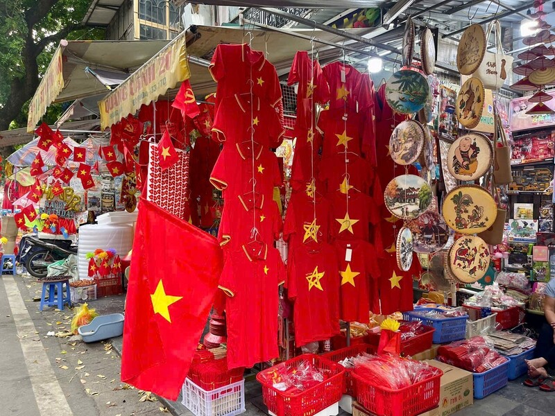 Một trong những mặt hàng bán chạy nhất là áo thun in cờ đỏ sao vàng, được trưng bày nổi bật trên phố Hàng Mã.