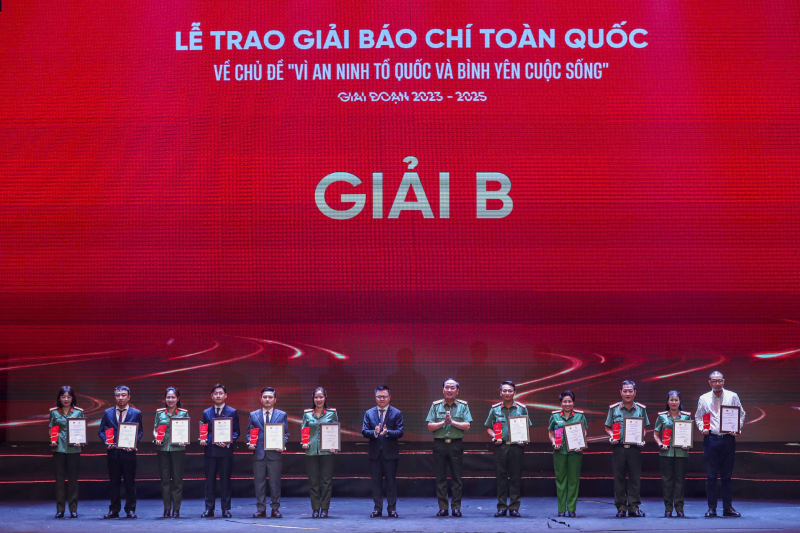 Thượng tướng Trần Quốc Tỏ, Ủy viên Trung ương Đảng, Thứ trưởng Bộ Công an và nhà báo Lê Quốc Minh, Ủy viên Trung ương Đảng, Tổng biên tập Báo Nhân dân, Chủ tịch Hội Nhà báo Việt Nam trao giải B cho các tác giả, nhóm tác giả. Ảnh: Chiến Thắng