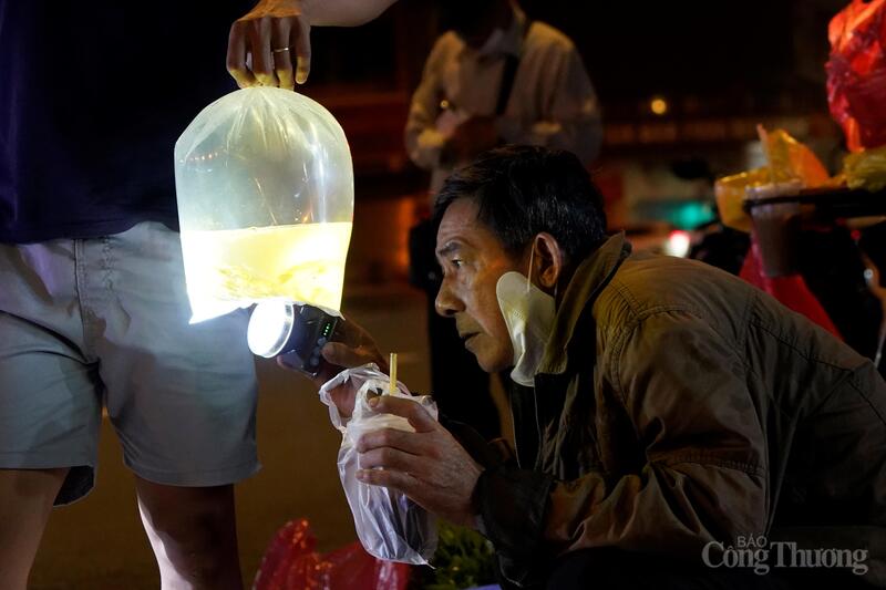 Vì trời tối, cả người bán lẫn người mua phải dùng đèn pin để soi cá