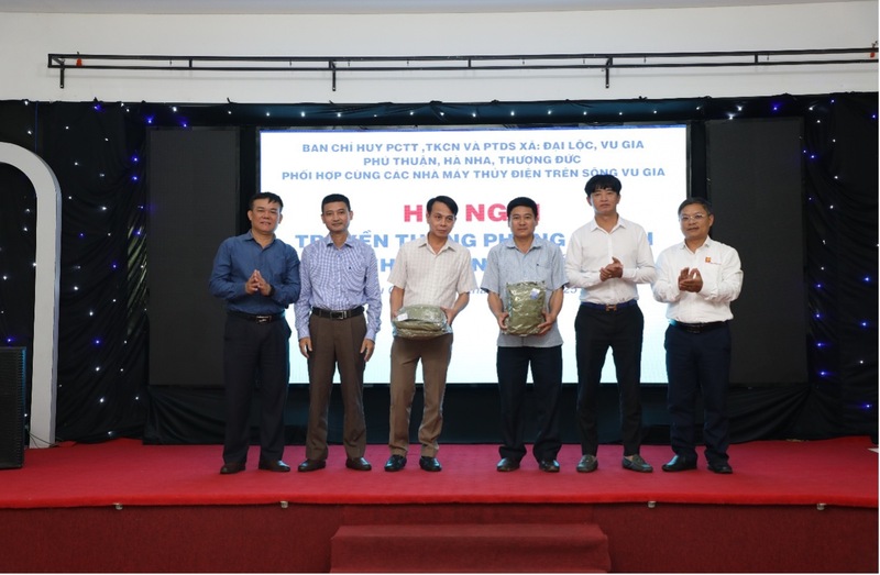 Ông Võ Trà Dũng, thành viên HĐQT Công ty CP Thủy điện A Vương (thứ 2 từ phải sang) cùng các nhà máy thủy điện trao tặng áo mưa phòng chống lụt bão cho Ban Chỉ huy PCTT các xã. Ảnh: Bình An