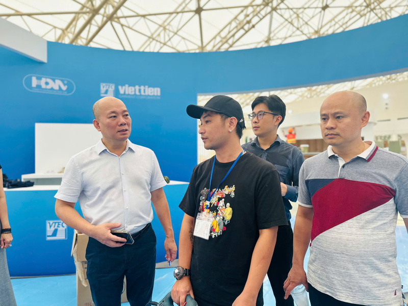 Ông Vũ Bá Phú, Cục trưởng Cục Xúc tiến Thương mại trao đổi tiến độ thi công với các doanh nghiệp tham gia triển lãm. Ảnh: Đỗ Nga