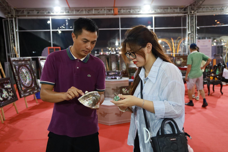 Nghệ nhân Vũ Văn Hoàng đang giới thiệu về các sản phẩm khảm trai, ốc.