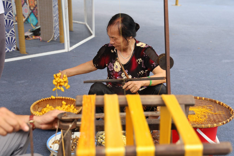 Nghệ nhân trình diễn se tơ tằm tại Hội chợ triển lãm Hàng lưu niệm quà tặng Thủ đô 2025.
