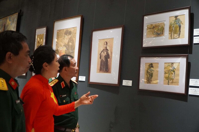 Hoạ sĩ Nguyễn Thị Thu Thuỷ giới thiệu các tác phẩm tới các đại biểu tham dự tại triển lãm. Ảnh: Hoa Quỳnh