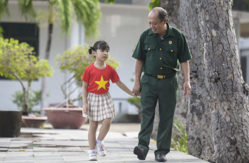 Thượng sĩ Nguyễn Chí Tường cùng con một nhân viên Vinamilk tại Trung tâm Điều dưỡng Thương binh và Người có công Long Đất (Ảnh: Thanh Bình).