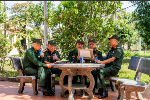 Các bác cựu chiến binh chăm chú đọc những dòng chữ nhỏ, được các em gửi kèm trong mỗi bức tranh (Ảnh: Duy Cường).