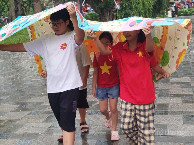 Một số bạn nhỏ sử dụng những chiếc chiếu mang theo để chống mưa.