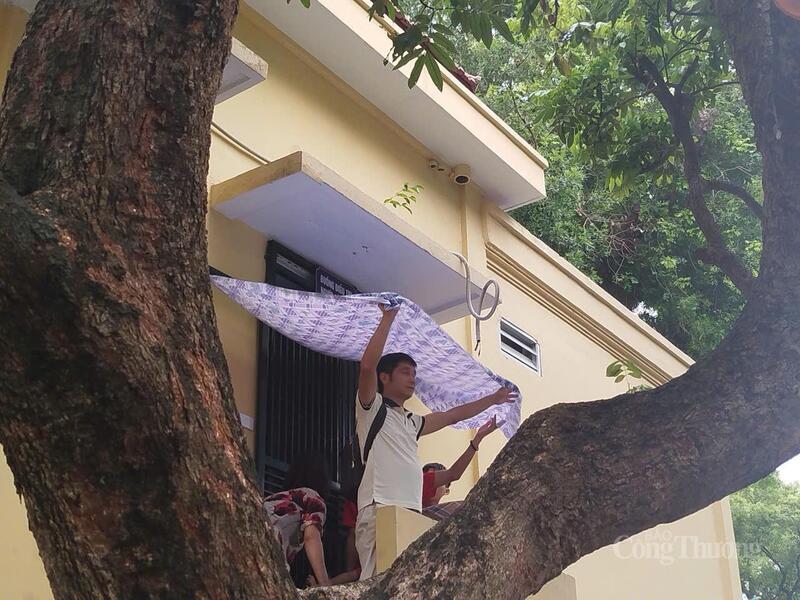 Một số người dân tìm được vị tránh mưa lý tưởng ở tầng 2 một ngôi nhà để xem đoàn diễu binh đi qua.